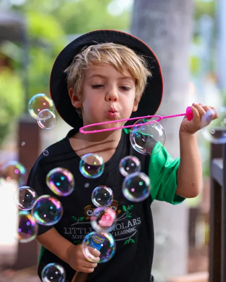 Little Scholars School of Early Learning: A boy blowing bubbles