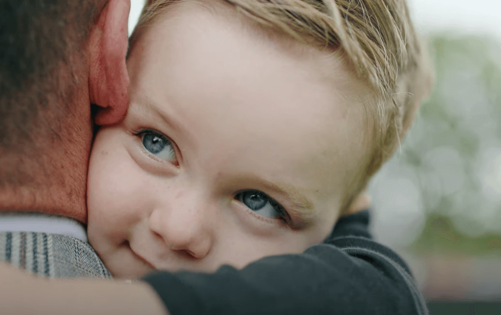 Close Up Of A Happy, Young Little Scholars Student Embracing A Parent Or Trusted Adult Figure