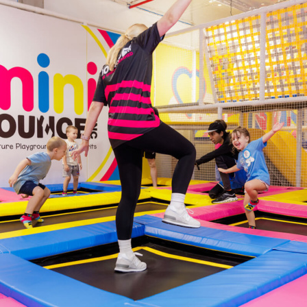 Children and staff playing on colorful trampolines at BOUNCE Mini Bounce Zone indoor playground in Australia.