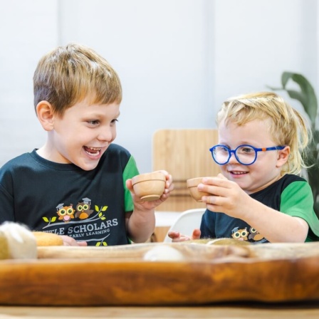 Toddlers engaging in social play and sensory learning with wooden toys at Little Scholars childcare centre.