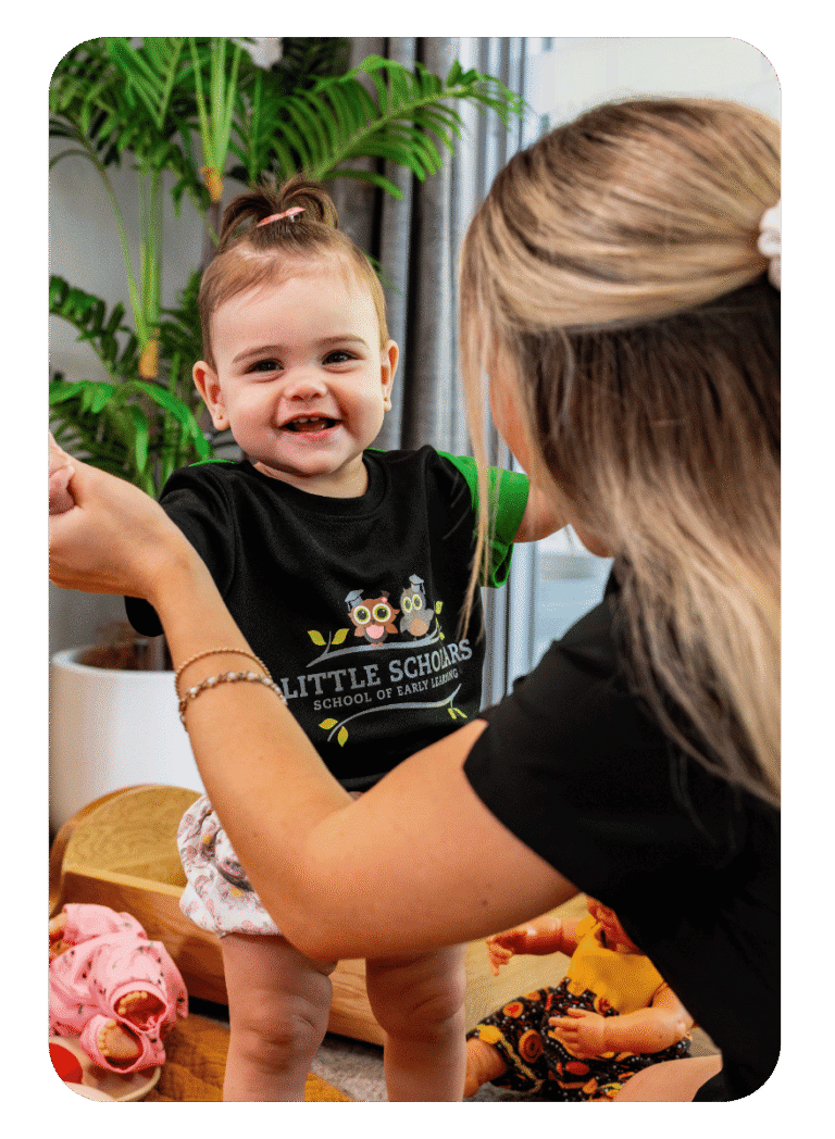 Early Childhood Educator Playing With Happy Baby